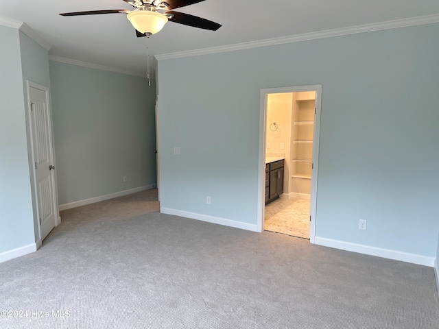 carpeted empty room featuring ceiling fan and crown molding