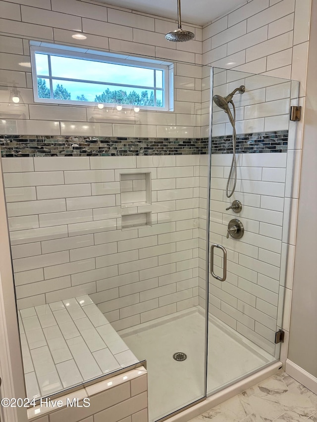 bathroom with a shower with door and plenty of natural light