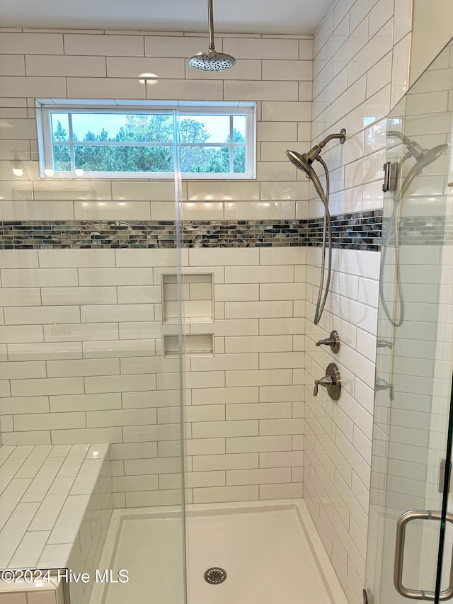 bathroom featuring a wealth of natural light and a shower with shower door