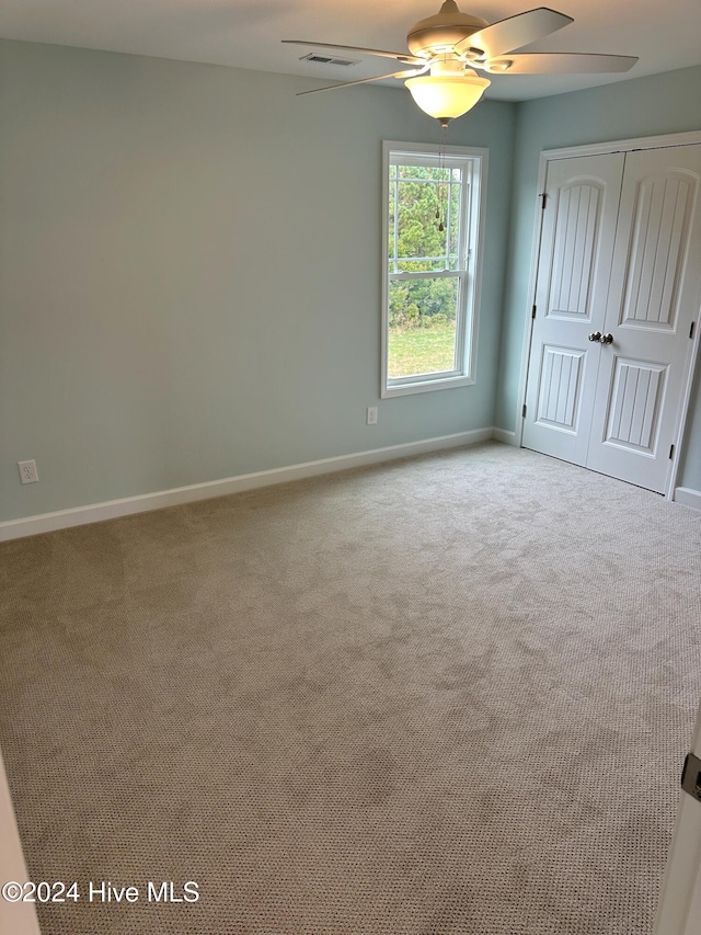 carpeted empty room featuring ceiling fan