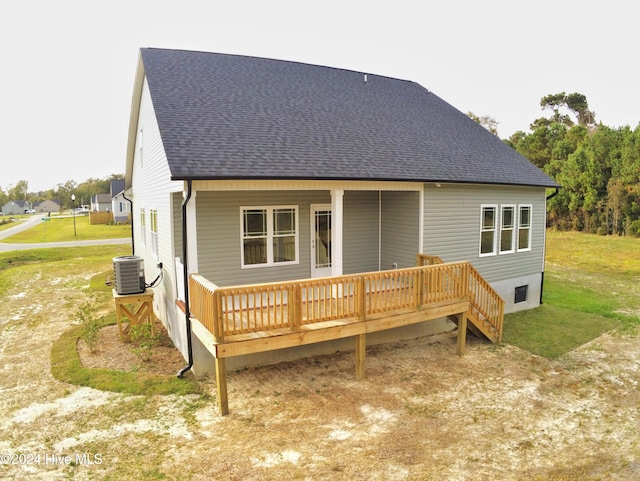 rear view of house featuring central air condition unit, a yard, and a deck