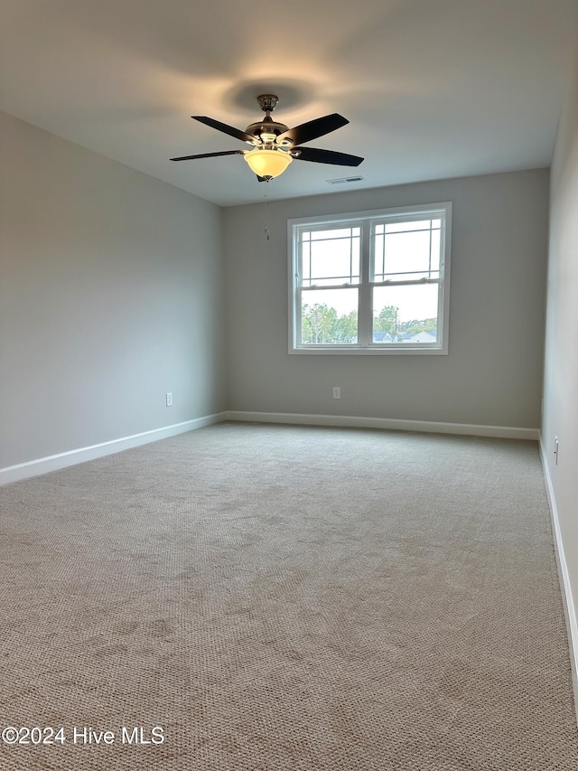 empty room with ceiling fan and light colored carpet