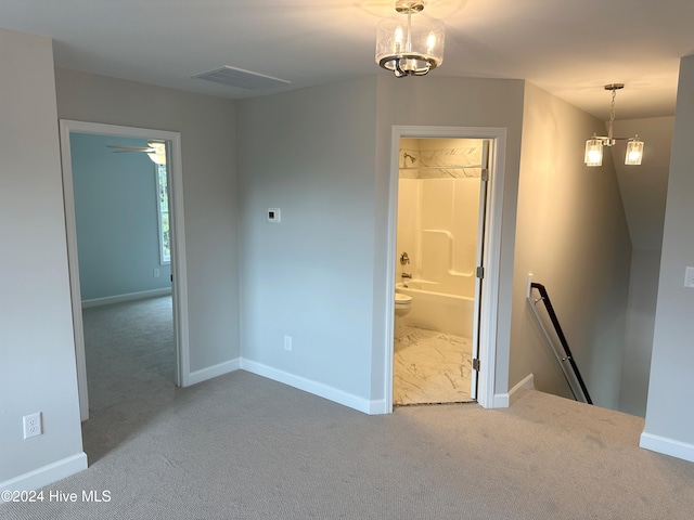 empty room featuring carpet and a chandelier