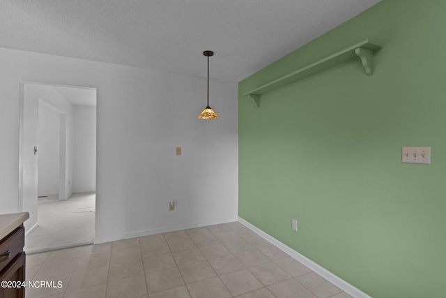 unfurnished dining area with light tile patterned flooring and a textured ceiling