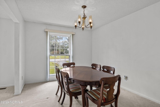 carpeted dining area featuring a notable chandelier and a textured ceiling