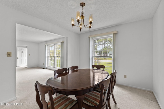 carpeted dining area featuring a textured ceiling and an inviting chandelier