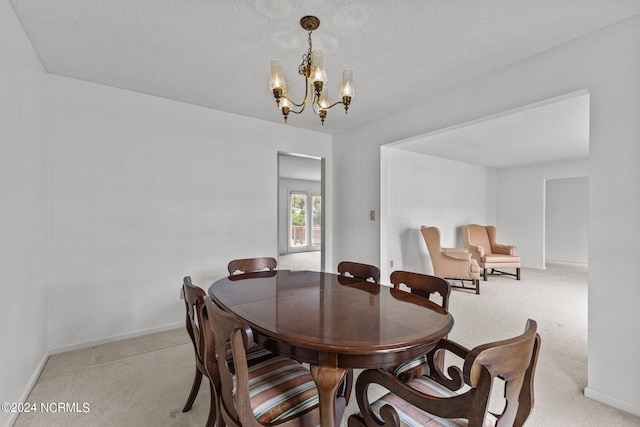 carpeted dining space featuring a textured ceiling and a chandelier