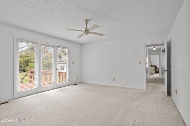 empty room featuring light colored carpet, a textured ceiling, and ceiling fan