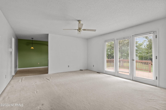 carpeted spare room with a textured ceiling and ceiling fan