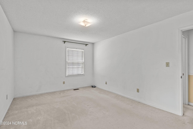 carpeted empty room with a textured ceiling