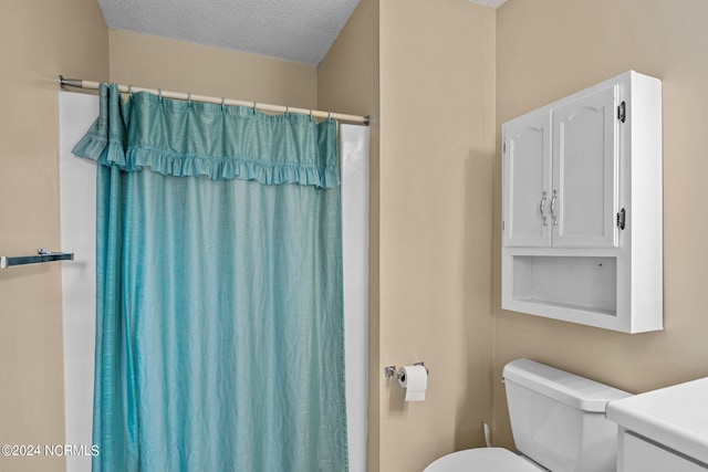 bathroom with a textured ceiling, vanity, toilet, and a shower with curtain