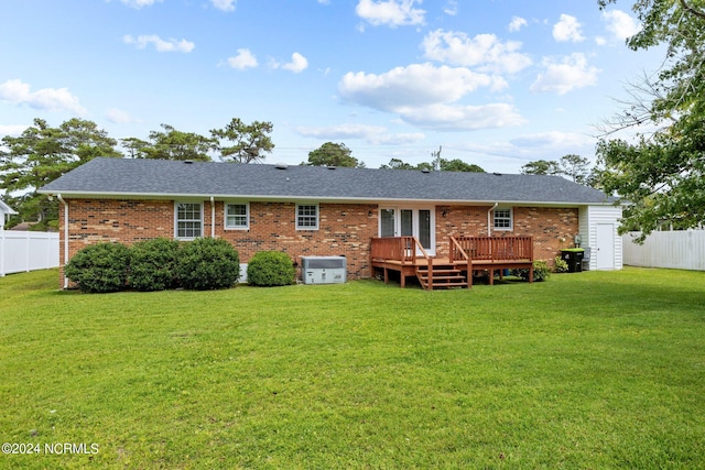 rear view of property with a yard and a wooden deck