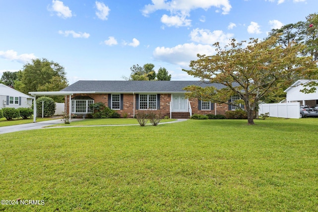 ranch-style house featuring a carport and a front lawn