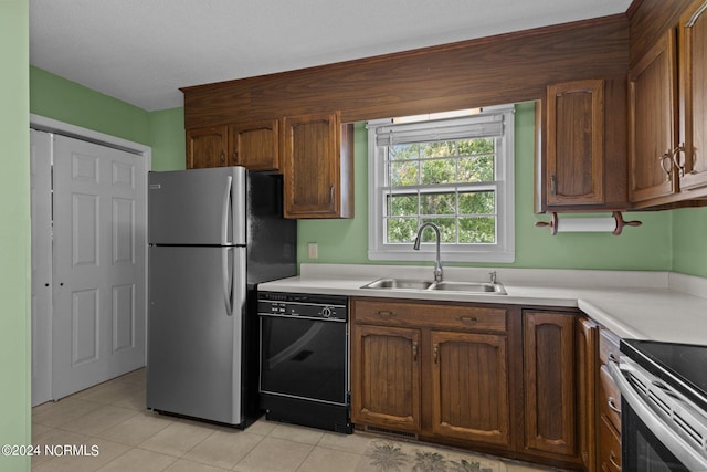 kitchen featuring light tile patterned floors, stainless steel appliances, and sink