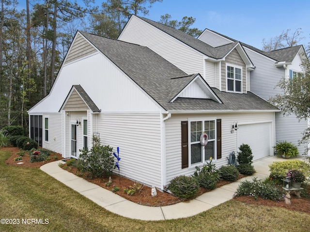 traditional home with a shingled roof and a front lawn