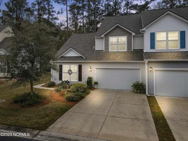 view of front of home featuring driveway, roof with shingles, and an attached garage