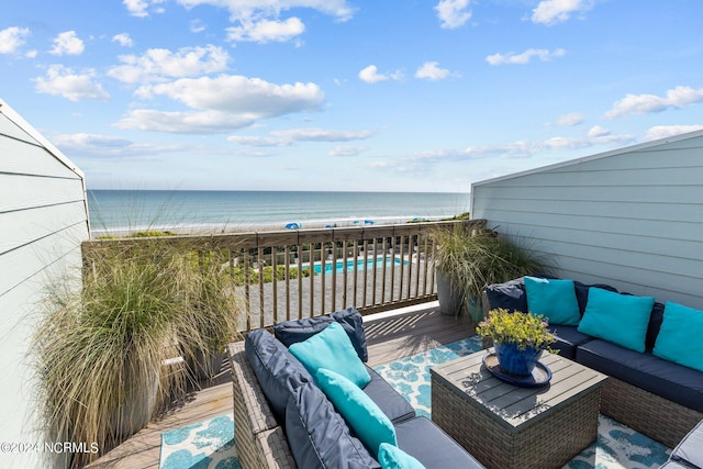 balcony featuring a beach view, a deck with water view, and outdoor lounge area