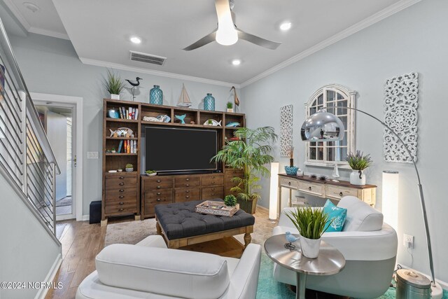 living room featuring crown molding, light hardwood / wood-style flooring, and ceiling fan