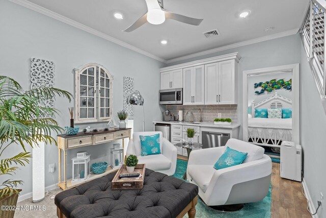 sitting room with crown molding, ceiling fan, and hardwood / wood-style floors