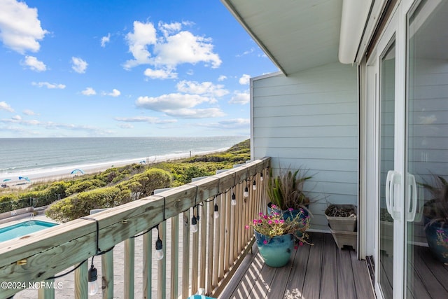 balcony featuring a water view and a beach view