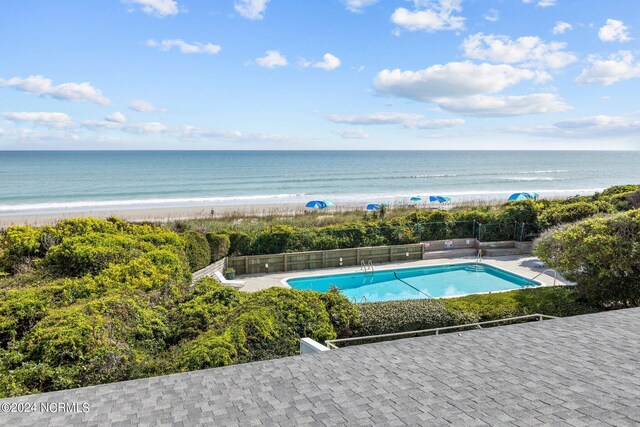 view of pool featuring a beach view and a water view