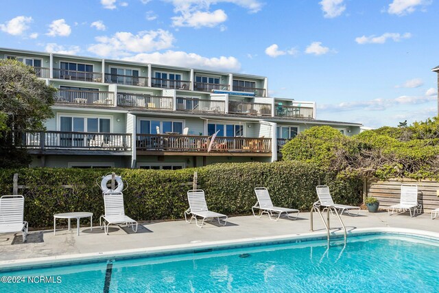 exterior space featuring a community pool and a balcony