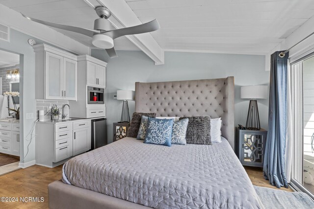 bedroom with ceiling fan, sink, vaulted ceiling with beams, and light hardwood / wood-style flooring