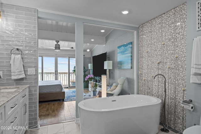 bathroom featuring vanity, vaulted ceiling, hardwood / wood-style floors, ornamental molding, and independent shower and bath