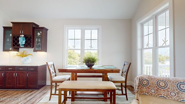 dining room with lofted ceiling and light hardwood / wood-style floors