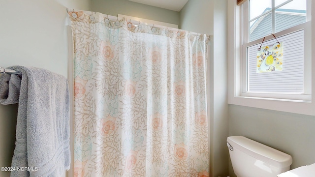 bathroom with toilet and a shower with curtain