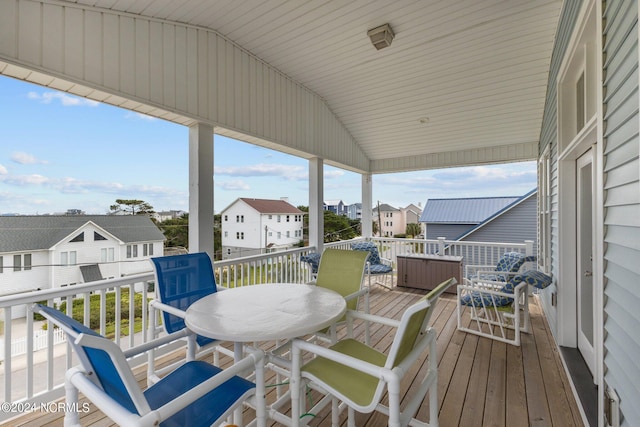 wooden terrace featuring outdoor dining space and a residential view