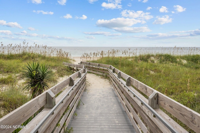 view of home's community with a water view and a beach view