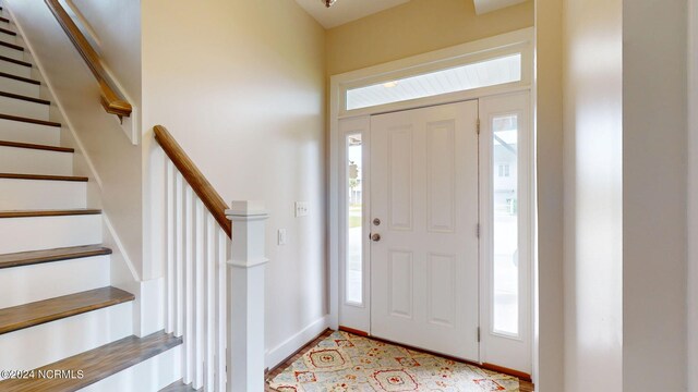 entryway with baseboards, stairway, and plenty of natural light
