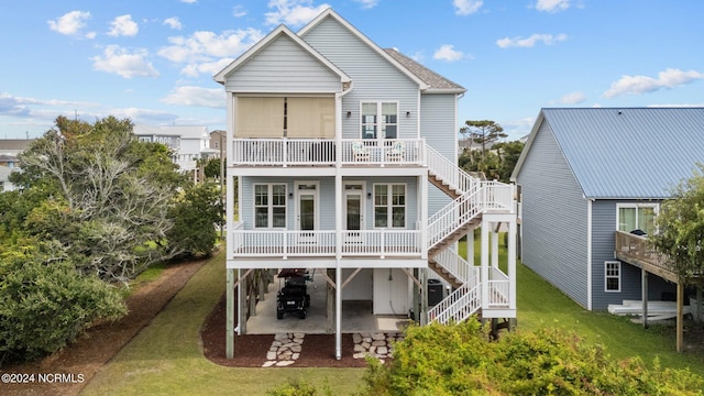 rear view of house featuring a patio, stairway, and a yard