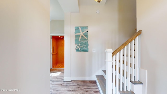 stairway featuring wood finished floors and baseboards