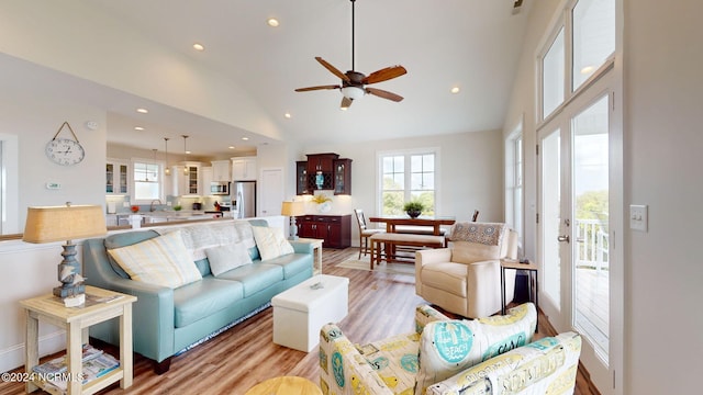 living room featuring light wood-type flooring, ceiling fan, high vaulted ceiling, and sink