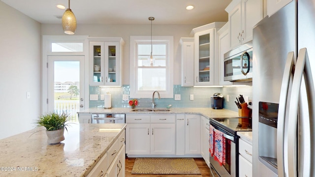 kitchen with a healthy amount of sunlight, decorative light fixtures, stainless steel appliances, and sink