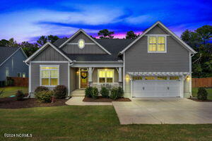 craftsman-style home with a garage, a porch, and a yard