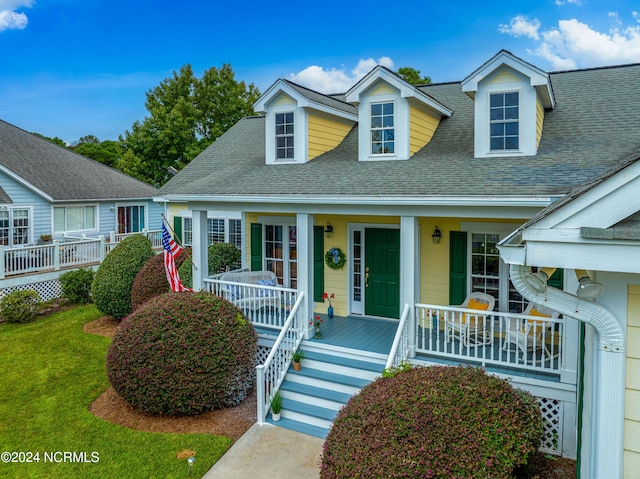 3184 Wild Azalea Way SE, Southport, NC 28461 - view of front of house with covered porch, a shingled roof, and a front lawn
