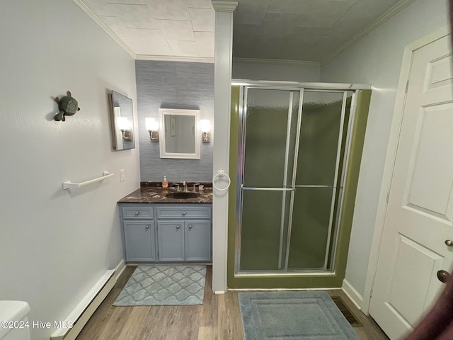 bathroom featuring ornamental molding, wood-type flooring, an enclosed shower, and a baseboard heating unit