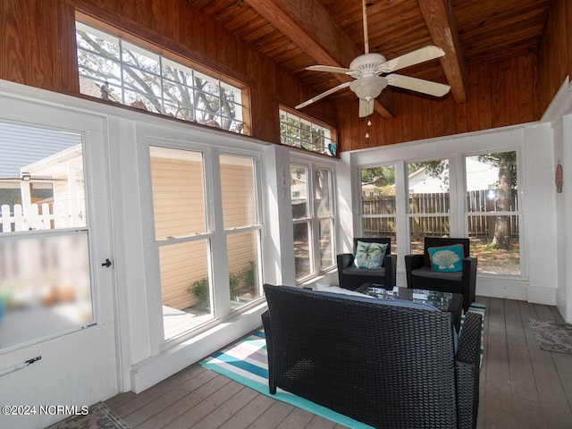 sunroom / solarium with beam ceiling, a wealth of natural light, ceiling fan, and wood ceiling