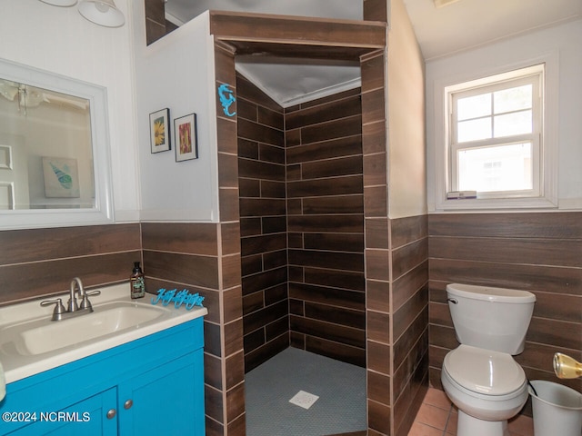 bathroom featuring tile patterned flooring, vanity, toilet, and a tile shower