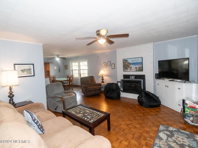 living room with ceiling fan, parquet flooring, crown molding, and a brick fireplace