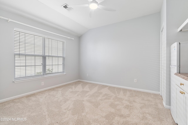 carpeted spare room featuring ceiling fan and lofted ceiling