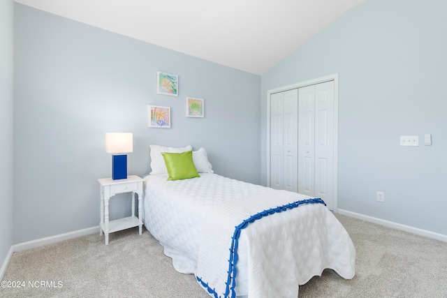 carpeted bedroom with a closet and vaulted ceiling