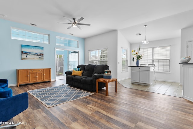 living room featuring lofted ceiling, light hardwood / wood-style flooring, and ceiling fan