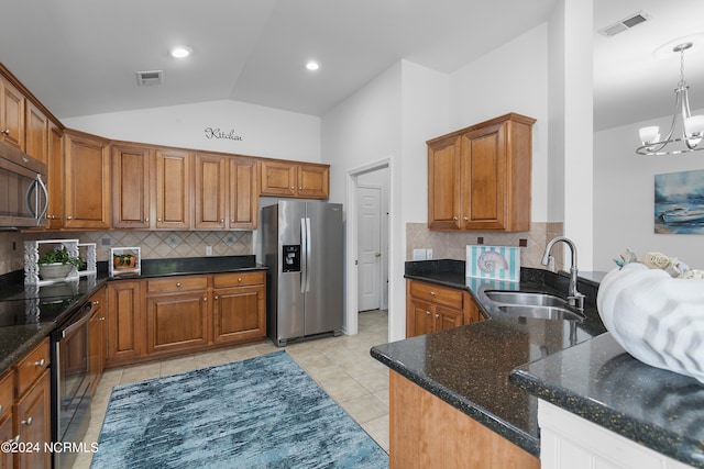 kitchen with pendant lighting, sink, a chandelier, appliances with stainless steel finishes, and vaulted ceiling