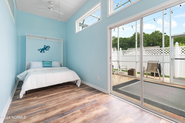 bedroom featuring hardwood / wood-style flooring and a towering ceiling