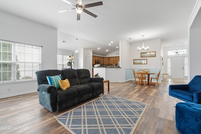 living room featuring ceiling fan with notable chandelier, hardwood / wood-style floors, and high vaulted ceiling