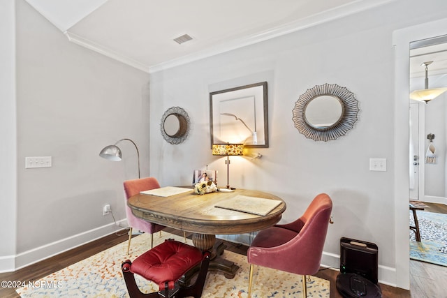 dining area featuring dark hardwood / wood-style flooring and ornamental molding